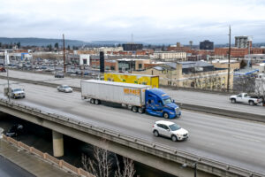 Werner Enterprises trucking company semi truck traveling through the downtown city center of Spokane, Washington USA on the Interstate 90 freeway.