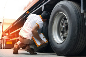 Truck diver inspecting safety daily check a truck tires.