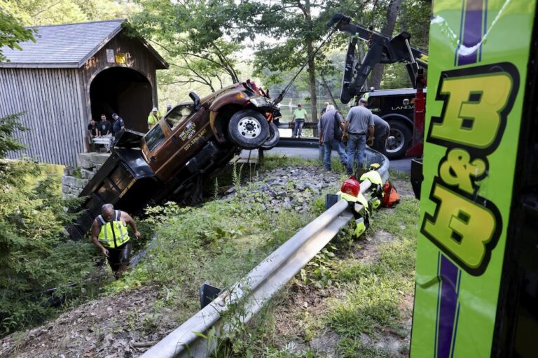 Dump truck leaves hole in covered bridge when it crashes into river in Maine