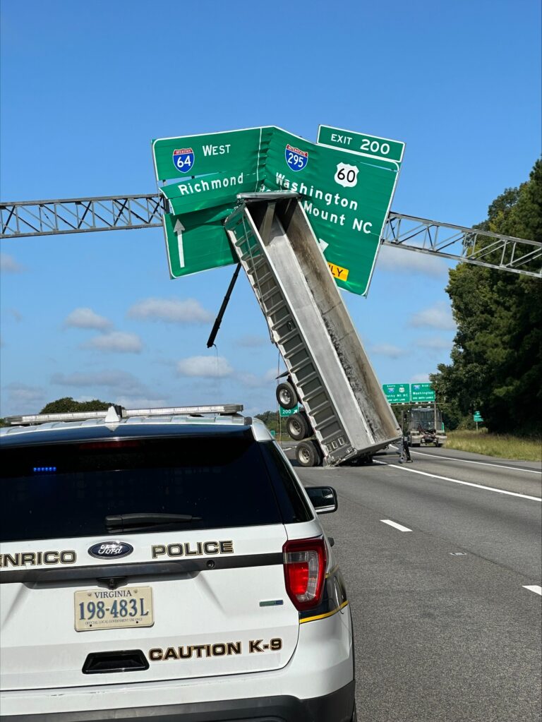 Semi’s trailer perched on highway sign sparks curiosity