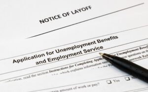 Job layoff notice and application for unemployment insurance benefits paperwork. Concept of Covid 19 coronavirus and stay at home order impact on economy