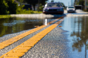 Car driving through flooded road after storm