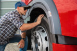 Truck Driver Inspecting the Tire