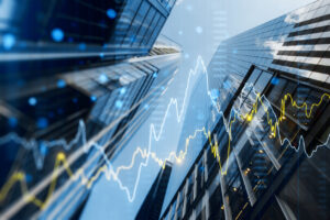 A double exposure image of skyscrapers with overlay of financial graphs, set against a blurred background, illustrating the concept of business growth