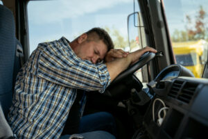 Tired, exhausted truck driver sleeping on the wheel, having rest or brake