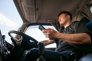 Truck driver driving while operating a smartphone