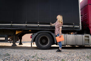 Female truck driver inspecting trailer before the road