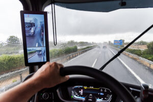 View from the driver's seat of a truck on a highway under heavy rain that prevents good visibility.