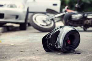 Close up of a helmet of a driver with a blurred motorbike and car in the background