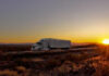 Truck on deserty road at sunset