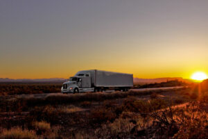 Truck on deserty road at sunset