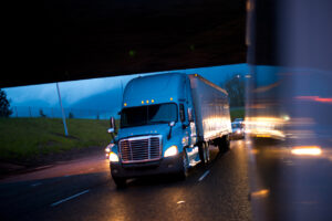 Bright semi truck in raining night lights on highway