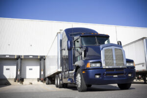 Blue Transport truck docking at warehouse