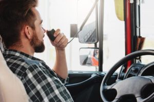 Truck driver talking by CB radio system in his vehicle