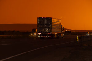 Trucks and traffic on the highway at sunset