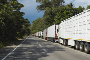 semi trucks waiting in a row near border. traffic jam.