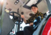 Low angle portrait of a woman sitting in the cab of a tractor. Agricultural and construction dealership, machinery leasing service.