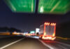 Defocused blurred motion of semitruck speeding on highway road speedway