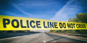 Police line. Warning yellow tape, text do not cross, blur highway road background. 3d illustration