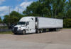 Big rig powerful professional industrial semi truck for long haul delivery commercial cargo with refrigerator semi trailer on the truck stop parking.